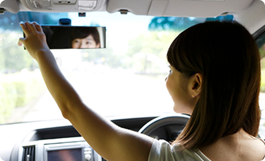 バックミラーを直す女性